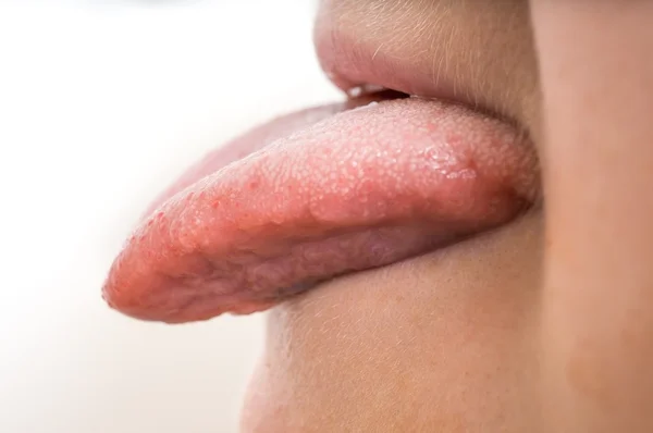 La mujer está sacando la lengua. Aislado sobre fondo blanco . — Foto de Stock