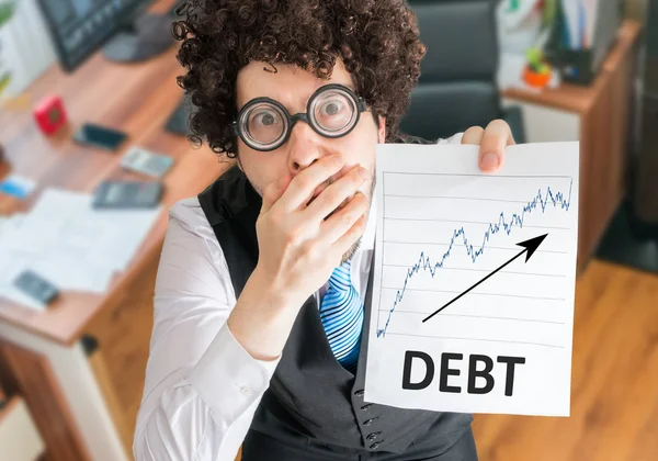 Šokovaný účetní ukazuje graf s rostoucí dluhy. — Stock fotografie