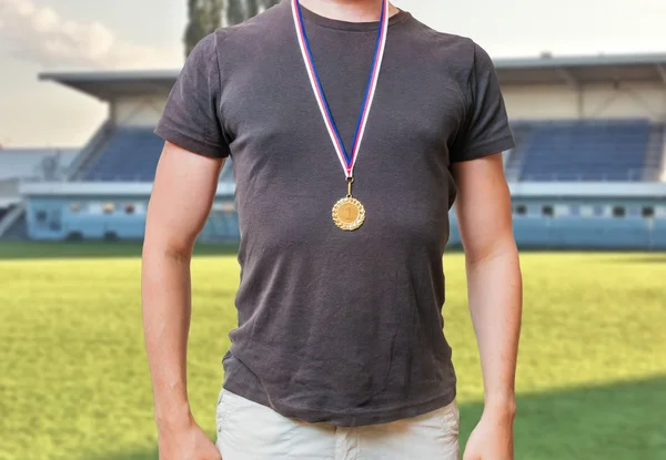 Sportsman está de pie en el estadio y lleva medalla de oro . —  Fotos de Stock