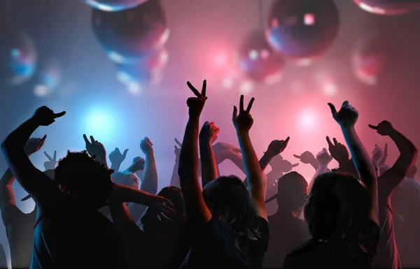 Vita notturna e discoteca concetto. Le silhouette dei giovani si divertono e ballano nel club . — Foto Stock