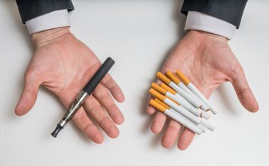El elektronik Buharlaştırıcı ve geleneksel tütün sigara tutan ve bunları karşılaştırarak.