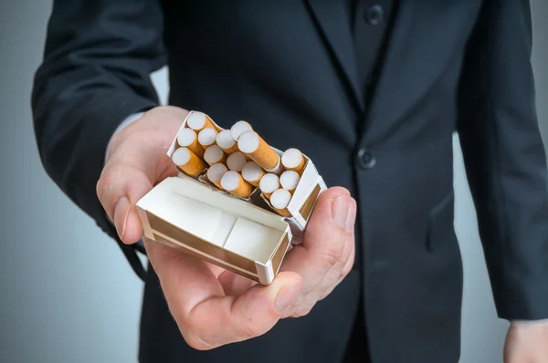 Ο άνθρωπος προσφέρει τσιγάρο από πακέτο τσιγάρων. — Φωτογραφία Αρχείου