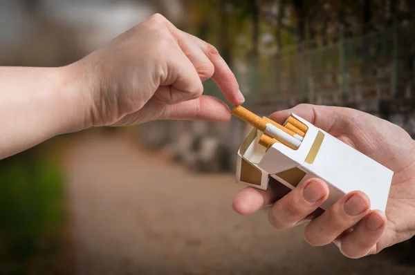 Mão está tomando cigarro de maço de cigarro e aceitar uma oferta . — Fotografia de Stock