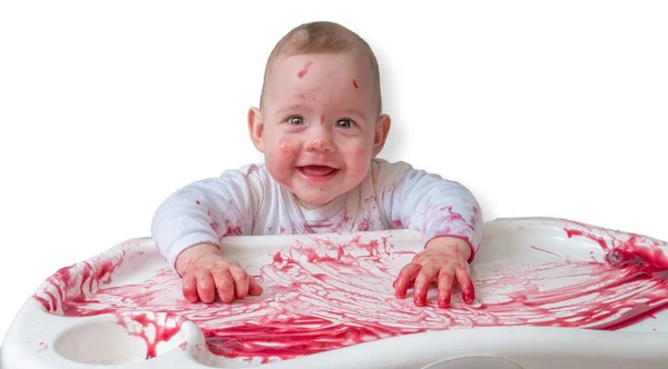 Bebé sujo bagunçado está sentado em cadeira alta e comendo lanche . — Fotografia de Stock