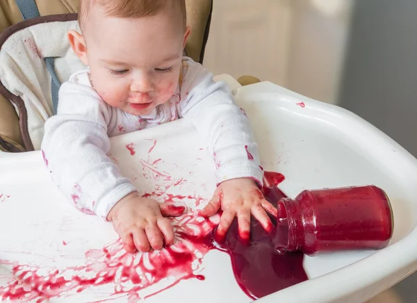 Messy and dirty baby is eating snack with hands. — Stock Photo, Image