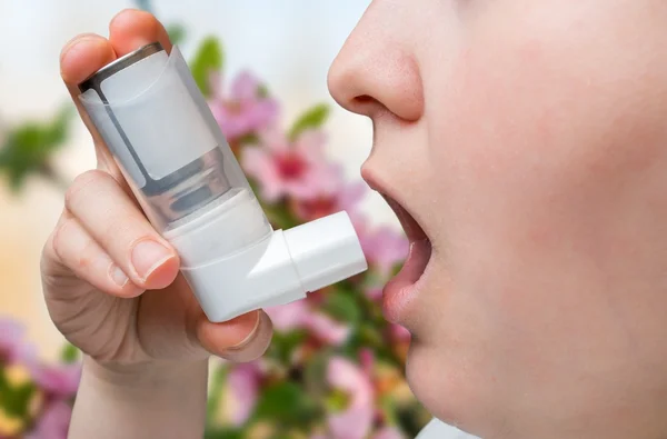 Astmatiska kvinna lider av astma och håller inhalatorn i hand. — Stockfoto