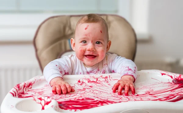 Messy and dirty baby is eating snack with hands. — Stock Photo, Image