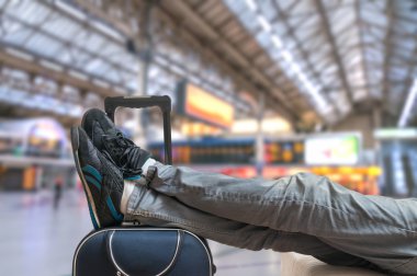 Gecikmeli tren kavramı. Yorgun yolcu Bagaj ile tren bekliyor