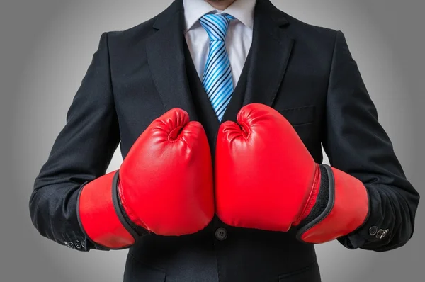 Empresario de boxeo con guantes rojos sobre fondo gris . —  Fotos de Stock