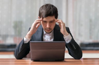 Genç niyetinde ve düşünme işadamı laptop ile çalışma.