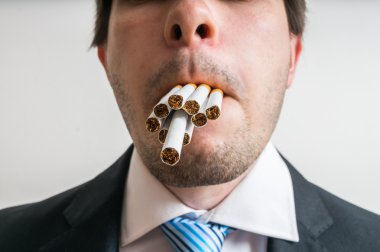 Genç adam tam ağzı sigara var. O anda pek çok sigara istiyor.