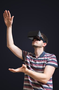 Genç adam 3d sanal gerçeklik gözlük takıyor. Siyah arka plan üzerine izole.