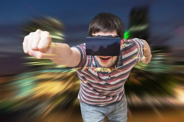 Молодой человек в 3D симуляции города. Он носит наушники виртуальной реальности . — стоковое фото