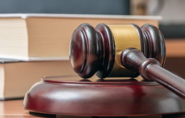 Açık artırma tokmak ile arka planda kitaplar. Adalet ve Müzayede kavramı.