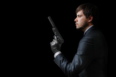 Murderer or assassin holding pistol with silencer. Mafia and crime concept. Low key photo. clipart