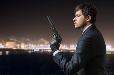 Gizli ajan silincer silahla elinde tutan geceleri.