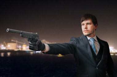 Gizli ajan veya casus tabanca ile geceleri hedefliyor.