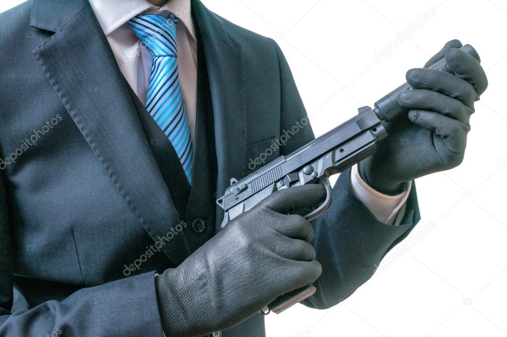 Secret agent or spy holds pistol with silencer in hands. Isolated on white background.