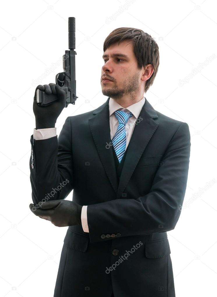 Man in suit holds pistol with silencer in hand. Isolated on white background.