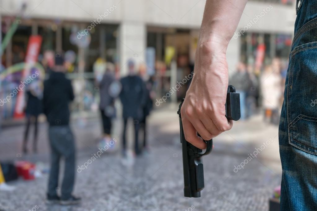 Robbery in store. Robber is aiming and threatening with gun in shop. Stock  Photo