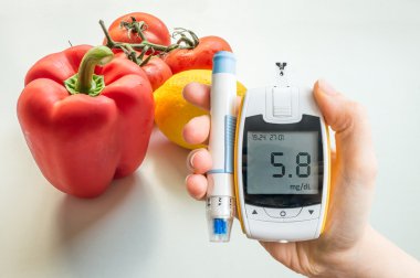 Diyabetik diyet, diyabet ve sağlıklı beslenme kavramı. Arka planda Glucometer aand sebzeler.