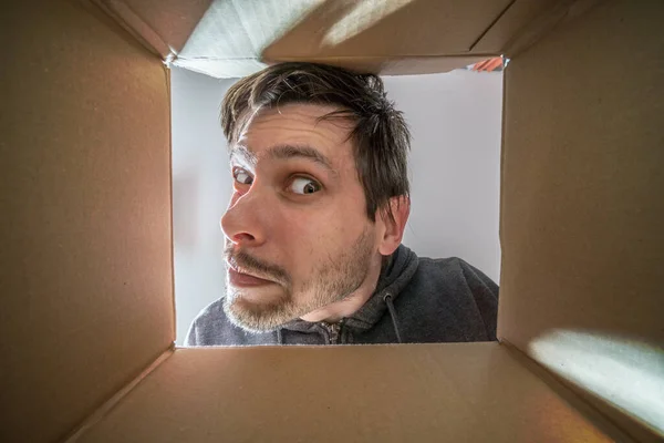 Joven Hombre Curioso Sospechoso Está Mirando Dentro Caja Cartón — Foto de Stock