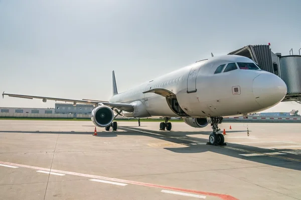 Avion dans l'aéroport avec porte d'embarquement pour les passagers — Photo