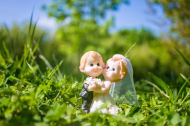 Evli çift heykelcik gelin ve damadın çimenlerin üzerinde