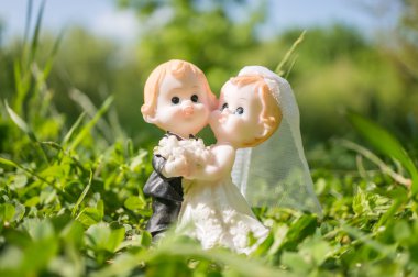 Married couple figurine of bride and groom on grass clipart