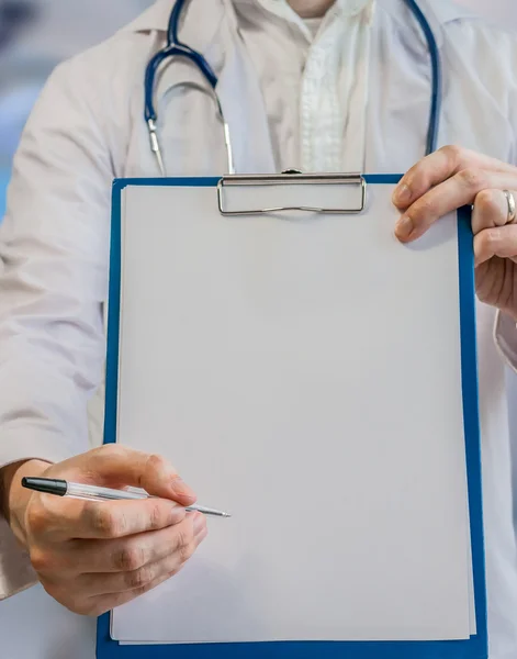 Doctor sostiene portapapeles con hoja de papel como marco para signatur — Foto de Stock