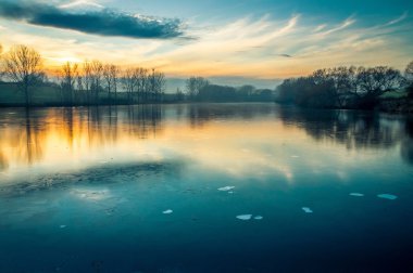 Kış akşamları donmuş ve buzlu gölette
