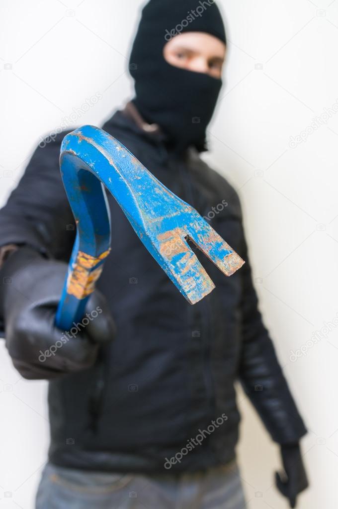 Crime concept. Criminal aggressive masked thief in black balacla