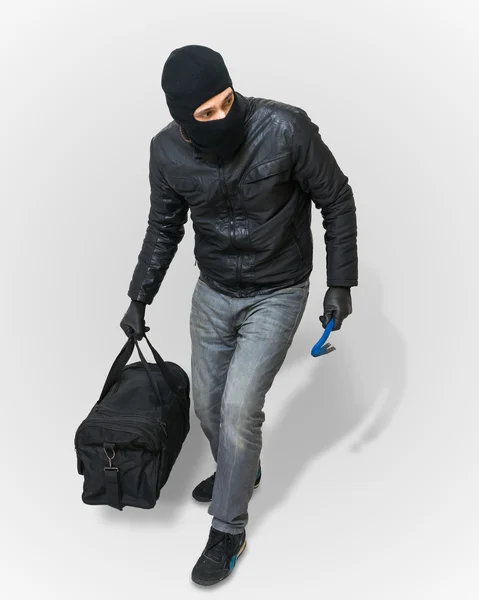 Maskierter Einbrecher oder Dieb mit Sturmhaube kriecht mit schwarzer Pistole — Stockfoto