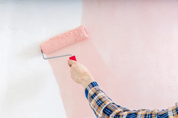 Renovación del interior. Pintores mano sostiene rodillo de pintura y pai — Foto de Stock
