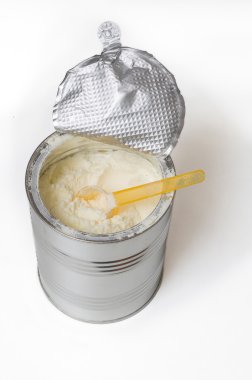 Kaşık toz bebek süt formülü üzerinde beyaz izole dolu
