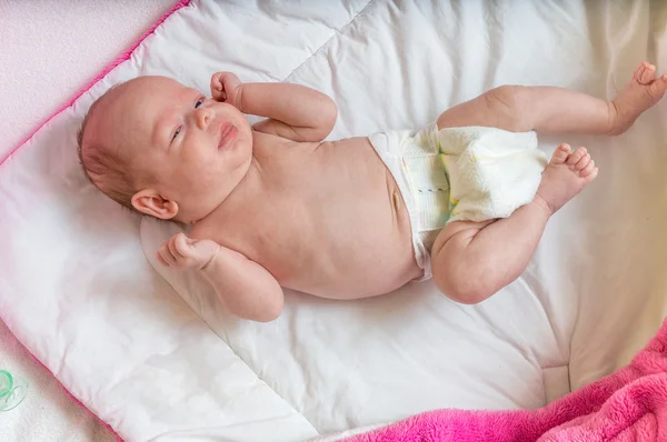 Adorable little baby girl in diaper is stretching — Stock Photo, Image