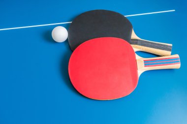 Raketleri ve ahşap masa üzerinde ping pong topu.