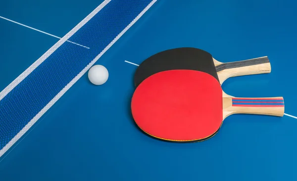 Ping pong πρόκληση. Ρακέτες πινγκ πονγκ στο μπλε τραπέζι. — Φωτογραφία Αρχείου