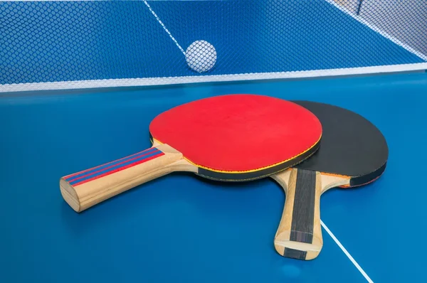 Schläger zum Tischtennisspielen vor einem Netz. — Stockfoto