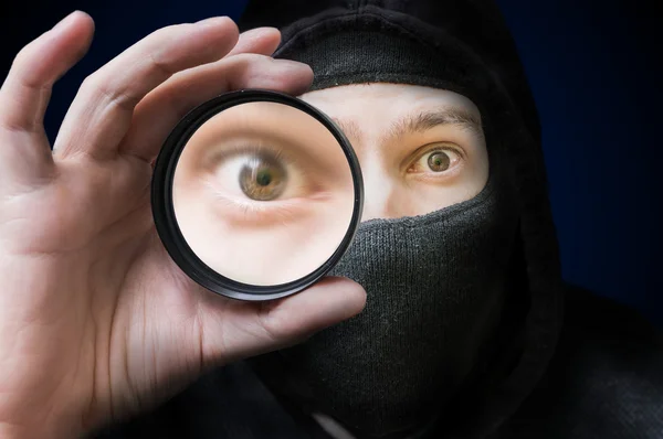 Masked anonymous hacker or spy is spying and doing espionage. — Stock Photo, Image