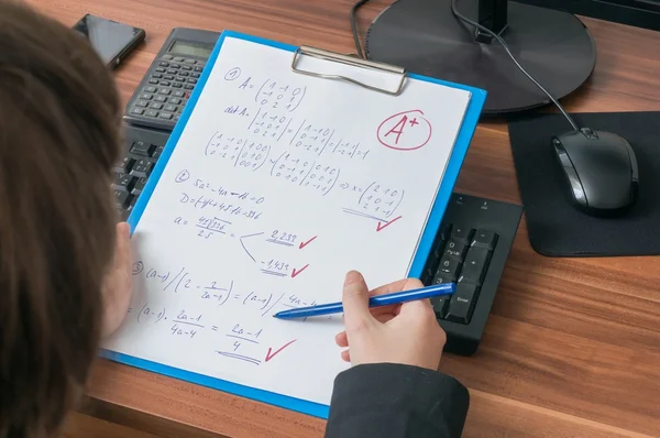 El profesor está corrigiendo y califica el examen de matemáticas en la escuela y da una calificación A más para un resultado excelente . —  Fotos de Stock