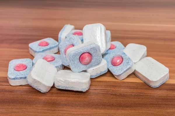 Dishwasher tablets on wooden table. Detergent for cleaning dishes — Stock Photo, Image