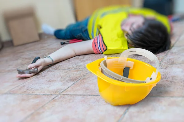 Work injury concept. Worker had an accident and is lying injured on the floor. — Stock Photo, Image