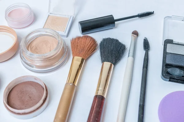 Nahaufnahme von Kosmetik, Make-up und Pinseln auf weißem Hintergrund. — Stockfoto