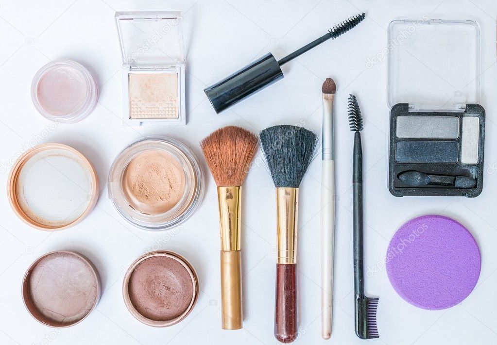 Flat view on cosmetics, makeup and brushes on white background.