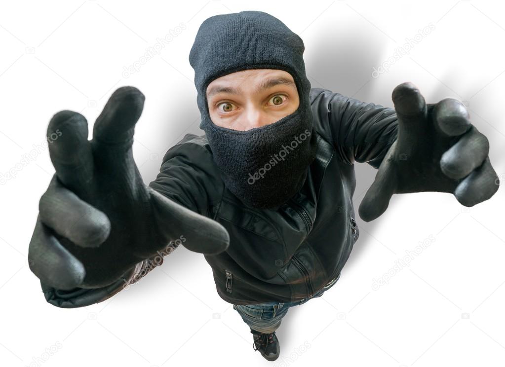 Funny burglar is stretching towards camera filming him from top.