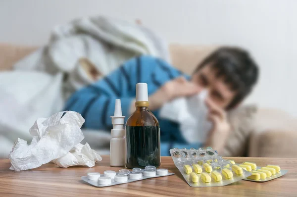 Comprimidos na frente do homem doente que tem gripe ou frio . — Fotografia de Stock