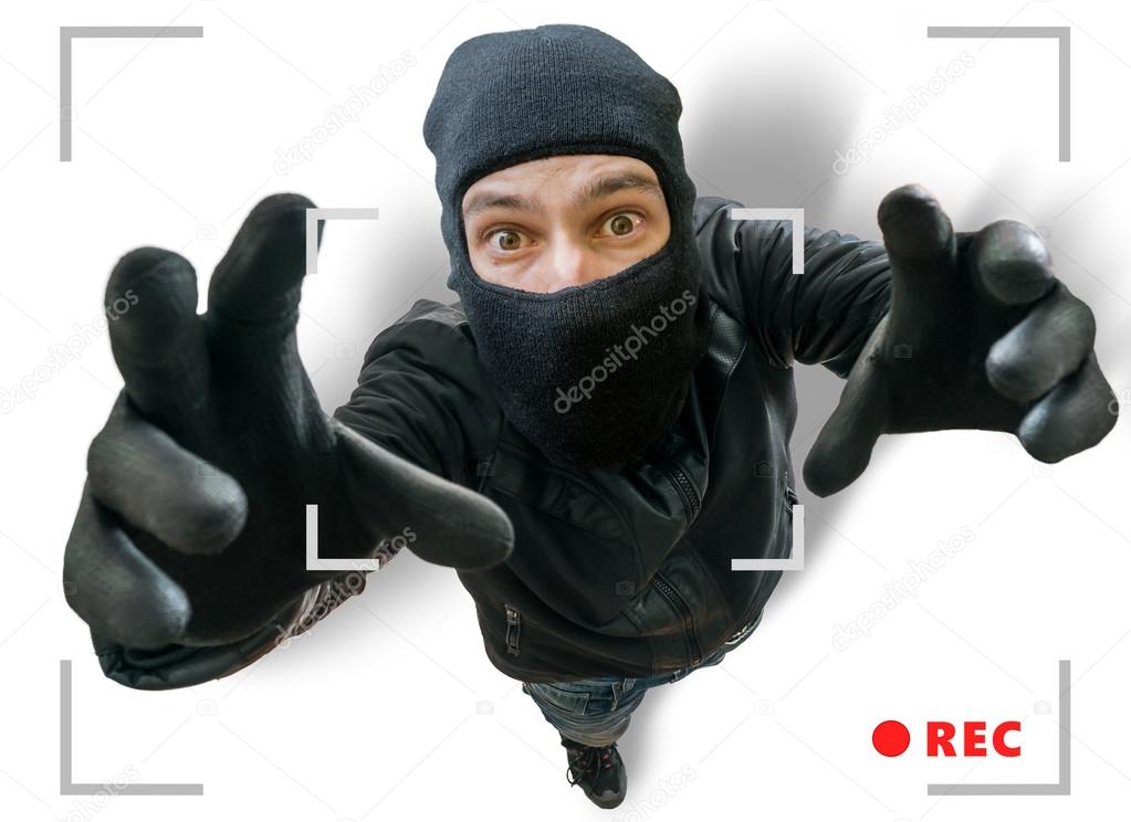 Masked thief or robber is recorded with security hidden camera.