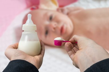 Ellerini tutar şişe süt formülü için besleme bebek dokusu ile.
