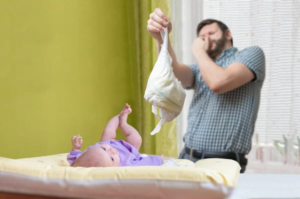 Baby care concept. Father od dad is changing stinky diaper. — Stock Photo, Image